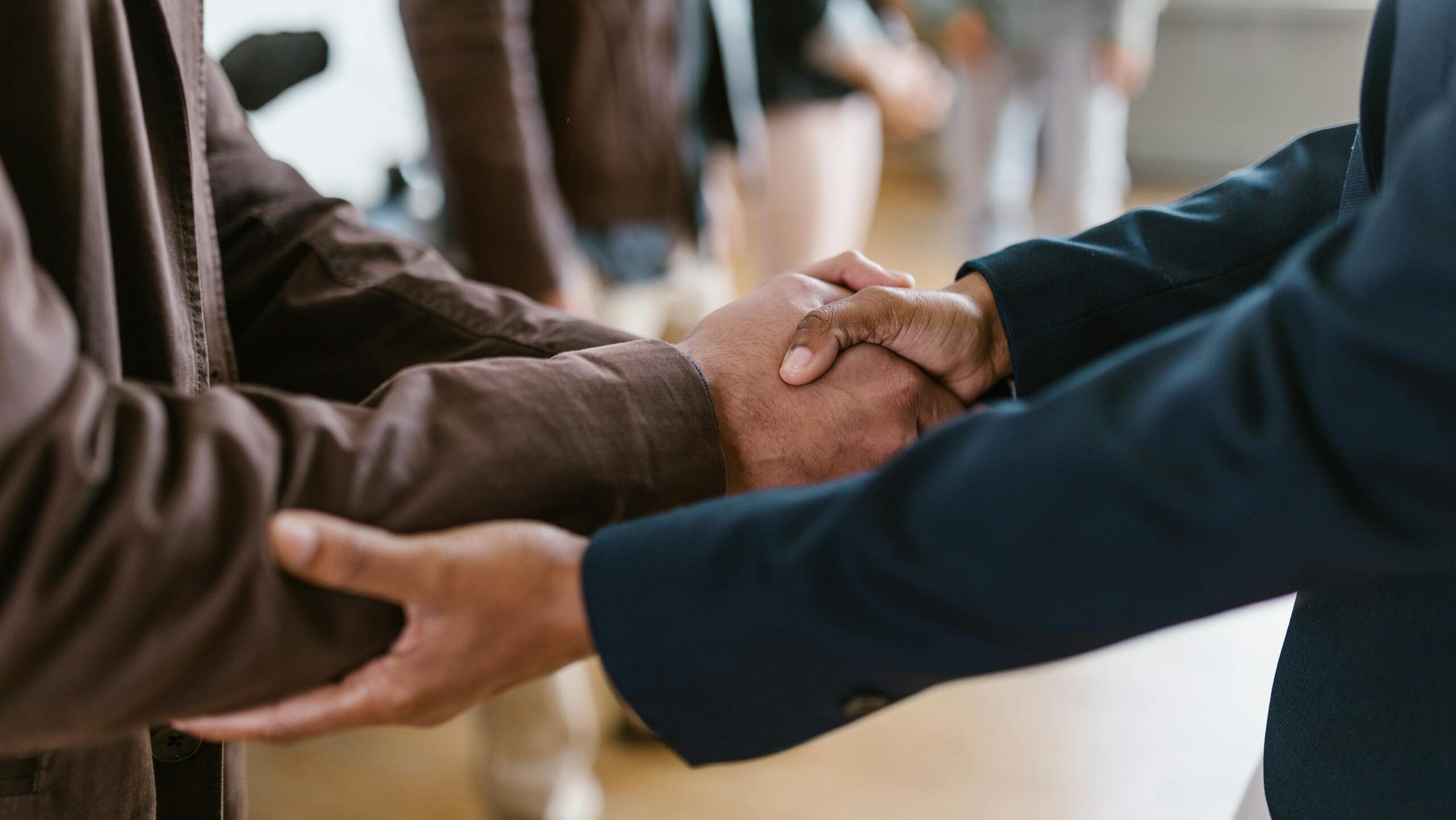 close up of two businesspeople shaking hands symbolizing agreement and partnership. 7414284 scaled e1734112652403